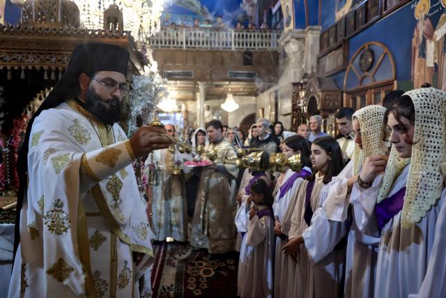 A priest uses a censer during Good Friday mass at the Greek Orthodox church of Saing Porphyrius in Gaza City on April 10, 2026. (Photo by Omar AL-QATTAA / AFP)