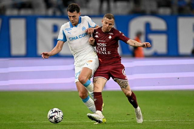 Marseille's French defender #28 Benjamin Pavard (L) and Metz's French midfielder #10 Gauthier Hein vie during the French L1 football match between Olympique de Marseille (OM) and Metz FC at the Stade Velodrome in Marseille, southern France on April 10, 2026. (Photo by Gabriel BOUYS / AFP)