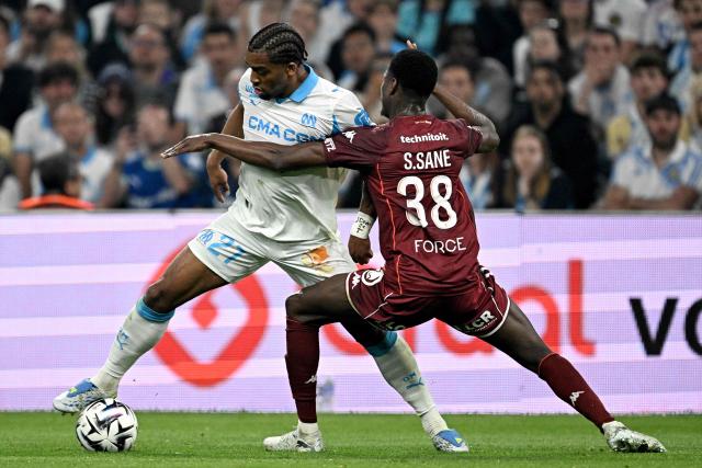Marseille's Dutch midfielder #27 Quinten Timber (L) fights for the ball with Metz' Senegalese defender #38 Sadibou Sane during the French L1 football match between Olympique de Marseille (OM) and Metz FC at the Stade Velodrome in Marseille, southern France on April 10, 2026. (Photo by Gabriel BOUYS / AFP)