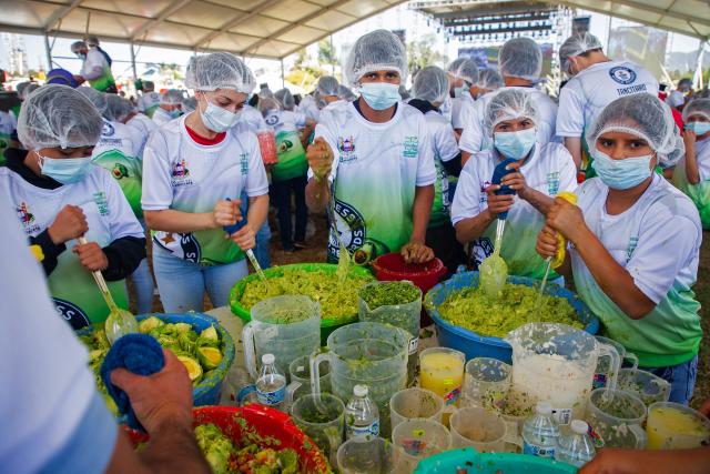 Participants prepare 6,800 kilos of Guacamole, a traditional Mexican dish made from avocados, tomatoes, onions, limes and coriander in Tancitaro, Michoacan state, Mexico on April 10, 2026. 800 people used 12 tons of avocados to complete the task on an attempt to break the Guinness World Record for the largest guacamole. Tancitaro is recognized as the "Avocado Capital," and the leading exporter of avocados to the US. (Photo by Enrique Castro / AFP)
