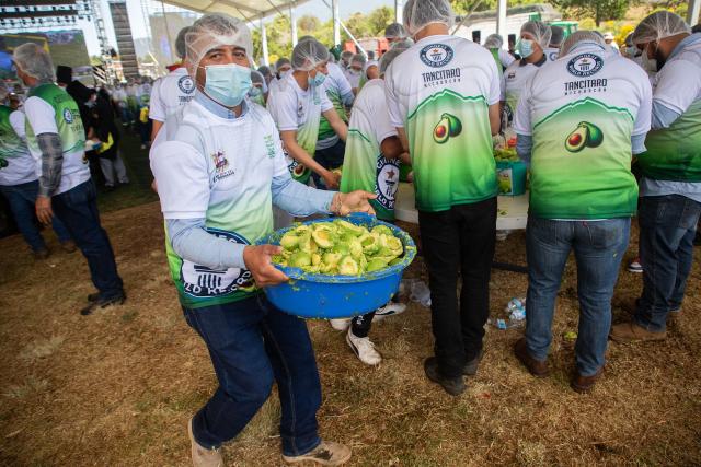 Participants prepare 6,800 kilos of Guacamole, a traditional Mexican dish made from avocados, tomatoes, onions, limes and coriander in Tancitaro, Michoacan state, Mexico on April 10, 2026. 800 people used 12 tons of avocados to complete the task on an attempt to break the Guinness World Record for the largest guacamole. Tancitaro is recognized as the "Avocado Capital," and the leading exporter of avocados to the US. (Photo by Enrique Castro / AFP)