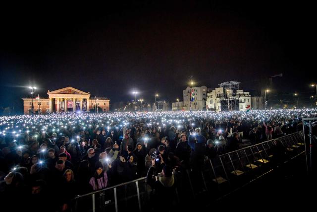 People attend the so-called concert ‘Rendszerbonto’ (“Demolition of the System”), which features more than 40 artists and is organized by the citizen resistance movement on Heroes’ Square in Budapest on April 10, 2026, two days before general elections. (Photo by Ferenc ISZA / AFP)