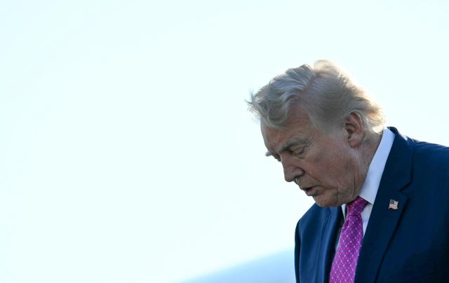 US President Donald Trump steps off Air Force One at Charlottesville-Albemarle Airport, Virginia on April 10, 2026. President Trump is in Charlottesville, Virginia to attend a MAGA inc. meeting and dinner at Trump Winery. (Photo by Jim WATSON / AFP)