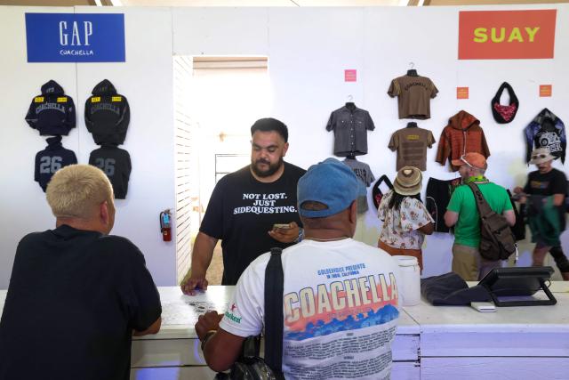 Festival-goers buy Coachella merchandise during the 2026 Coachella Valley Music and Arts Festival at Empire Polo Club in Indio, California on April 10, 2026. (Photo by VALERIE MACON / AFP)