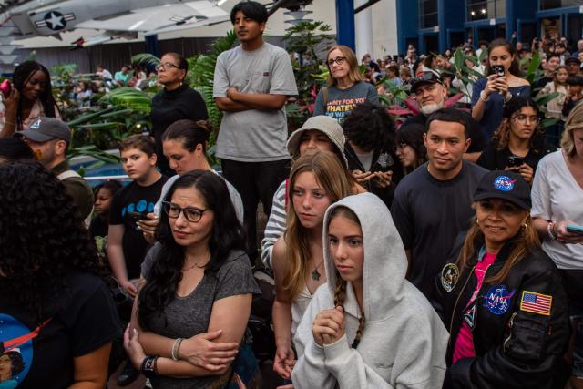 People watch a live broadcast of the return of the Artemis II crew members to Earth at the San Diego Air and Space Museum during a watch party for the crew's splash down in the Pacific Ocean, in San Diego, California, on April 10, 2026. The NASA spacecraft carrying four astronauts splashed down as planned Friday off the California coast, capping the US space agency's successful crewed test mission around the Moon, the first such flyby in more than 50 years. Mission commander Reid Wiseman reported that the crewmembers -- himself along with Christina Koch, Victor Glover and Jeremy Hansen -- were "stable" and "green." (Photo by Apu GOMES / AFP)