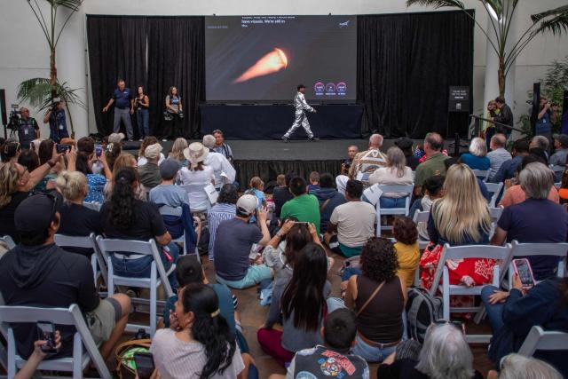 People watch a live broadcast of the return of the Artemis II crew members to Earth at the San Diego Air and Space Museum during a watch party for the crew's splash down in the Pacific Ocean, in San Diego, California, on April 10, 2026. The NASA spacecraft carrying four astronauts splashed down as planned Friday off the California coast, capping the US space agency's successful crewed test mission around the Moon, the first such flyby in more than 50 years. Mission commander Reid Wiseman reported that the crewmembers -- himself along with Christina Koch, Victor Glover and Jeremy Hansen -- were "stable" and "green." (Photo by Apu GOMES / AFP)