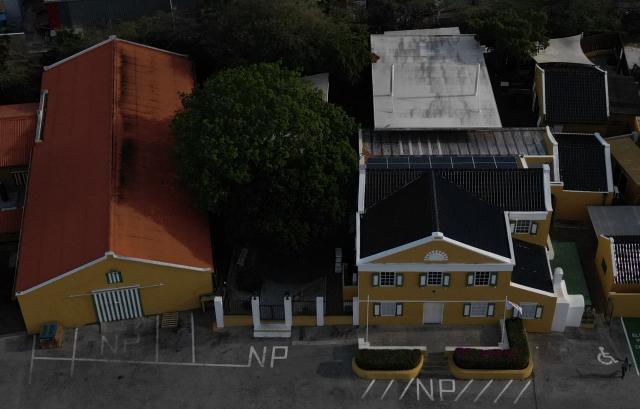 This aerial view shows The Curacao Liqueur Distillery in Willemstad, Curacao, in the Dutch Caribbean, on April 9, 2026. The iconic blue color of Curaзao liquor is not natural; it is obtained by adding a coloring agent designed to evoke the turquoise waters of the island’s idyllic Caribbean beaches. (Photo by Raul ARBOLEDA / AFP)