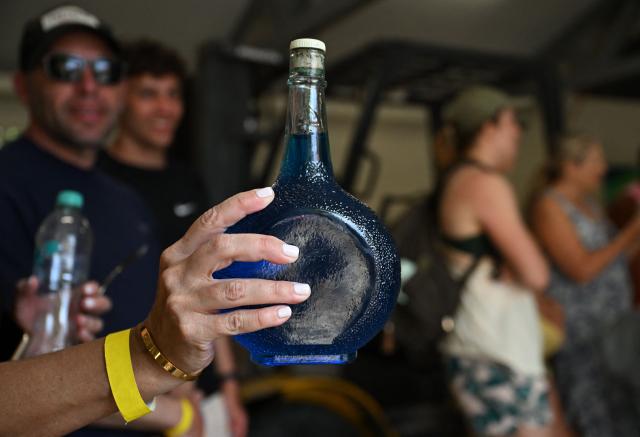 Tourists visit The Curacao Liqueur Distillery in Willemstad, Curacao, in the Dutch Caribbean, on April 9, 2026. The iconic blue color of Curaзao liquor is not natural; it is obtained by adding a coloring agent designed to evoke the turquoise waters of the island’s idyllic Caribbean beaches. (Photo by Raul ARBOLEDA / AFP)