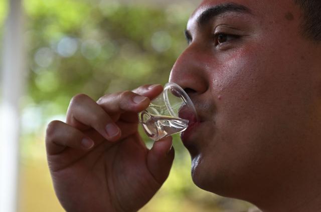 Alberto Cancino tastes liquor at The Curacao Liqueur Distillery in Willemstad, Curacao, in the Dutch Caribbean, on April 9, 2026. The iconic blue color of Curaзao liquor is not natural; it is obtained by adding a coloring agent designed to evoke the turquoise waters of the island’s idyllic Caribbean beaches. (Photo by Raul ARBOLEDA / AFP)