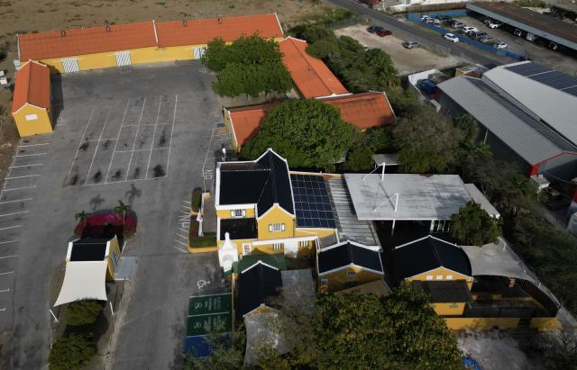 This aerial view shows The Curacao Liqueur Distillery in Willemstad, Curacao, in the Dutch Caribbean, on April 9, 2026. The iconic blue color of Curaзao liquor is not natural; it is obtained by adding a coloring agent designed to evoke the turquoise waters of the island’s idyllic Caribbean beaches. (Photo by Raul ARBOLEDA / AFP)