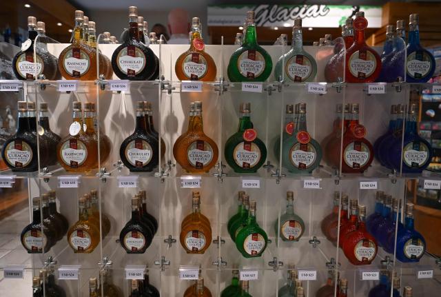 Curacao liquor bottles are seen at The Curacao Liqueur Distillery in Willemstad, Curacao, in the Dutch Caribbean, on April 9, 2026. The iconic blue color of Curaзao liquor is not natural; it is obtained by adding a coloring agent designed to evoke the turquoise waters of the island’s idyllic Caribbean beaches. (Photo by Raul ARBOLEDA / AFP)