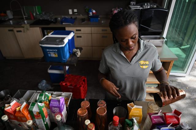 A bartender prepares a cocktail at The Curacao Liqueur Distillery in Willemstad, Curacao, in the Dutch Caribbean, on April 9, 2026. The iconic blue color of Curaзao liquor is not natural; it is obtained by adding a coloring agent designed to evoke the turquoise waters of the island’s idyllic Caribbean beaches. (Photo by Raul ARBOLEDA / AFP)