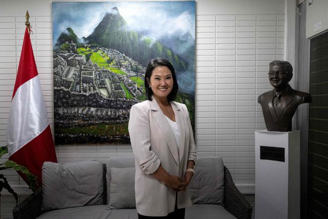 Peru's presidential candidate Keiko Fujimori, for the Fuerza Popular party, poses for a photo next to a bust of her father, former President Alberto Fujimori (1990-2000), during an interview with AFP at the party headquarters in Lima on April 10, 2026. Fujimori, the frontrunner in Peru's presidential race, vowed expel illegal migrants, attract US investment and extend a conservative tide sweeping power in Latin America, in an exclusive interview with AFP on April 10, 2026, on the eve of the April 12 election. (Photo by Ernesto BENAVIDES / AFP)