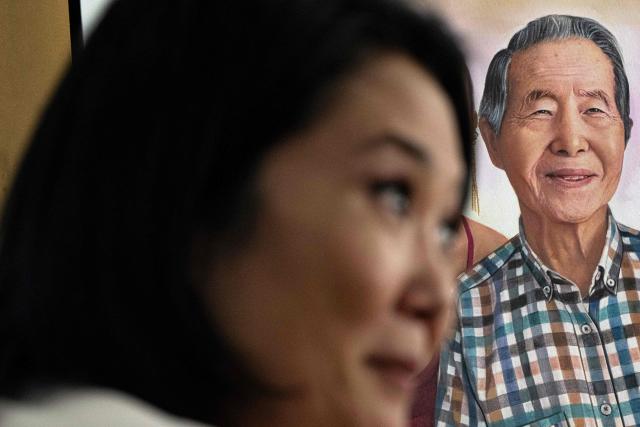 A portrait of former Peru's President Alberto Fujimori (1990-2000) is pictured as his daughter and presidential candidate Keiko Fujimori, for the Fuerza Popular party, speaks during an interview with AFP at the party headquarters in Lima on April 10, 2026. Fujimori, the frontrunner in Peru's presidential race, vowed expel illegal migrants, attract US investment and extend a conservative tide sweeping power in Latin America, in an exclusive interview with AFP on April 10, 2026, on the eve of the April 12 election. (Photo by Ernesto BENAVIDES / AFP)