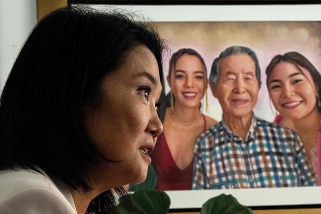 Peru's presidential candidate Keiko Fujimori, for the Fuerza Popular party, speaks during an interview with AFP, with a portrait of her father, former President Alberto Fujimori (1990-2000), and her daughters Kyara and Kaori in the background at the party headquarters in Lima on April 10, 2026. Fujimori, the frontrunner in Peru's presidential race, vowed expel illegal migrants, attract US investment and extend a conservative tide sweeping power in Latin America, in an exclusive interview with AFP on April 10, 2026, on the eve of the April 12 election. (Photo by Ernesto BENAVIDES / AFP)