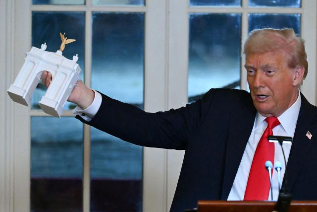 (FILES) US President Donald Trump holds up a model for a proposed "Independence Arch" as he speaks during a dinner with ballroom donors in the East Room of the White House in Washington, DC on October 15, 2025. The Trump administration unveiled plans on April 10, 2026 for a grand arch it intends to build in Washington, a new project by the American president designed to leave his mark on the US capital. "I am pleased to announce that TODAY my Administration officially filed the presentation and plans to the highly respected Commission of Fine Arts for what will be the GREATEST and MOST BEAUTIFUL Triumphal Arch, anywhere in the World," Trump wrote on his Truth Social platform. (Photo by ANDREW CABALLERO-REYNOLDS / AFP)