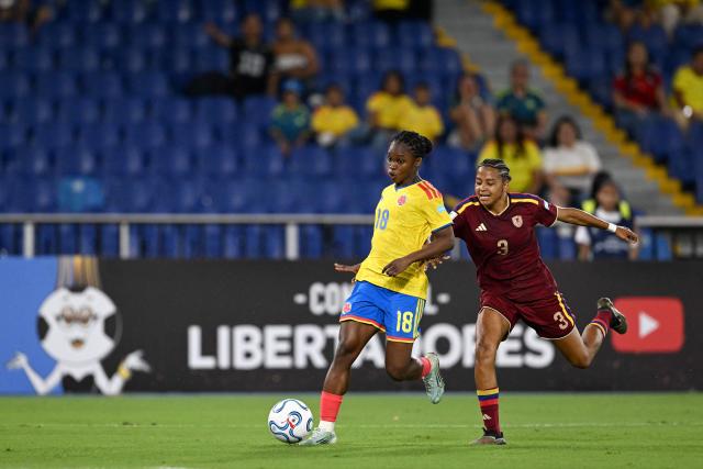 Colombia's forward #18 Linda Caicedo runs with the ball past Venezuela's defender #03 Barbara Martinez during the CONMEBOL Nations League Women football match between Colombia and Venezuela at the Olímpico Pascual Guerrero stadium in Cali, Valle del Cauca, Colombia, on April 10, 2026. (Photo by JOAQUIN SARMIENTO / AFP)