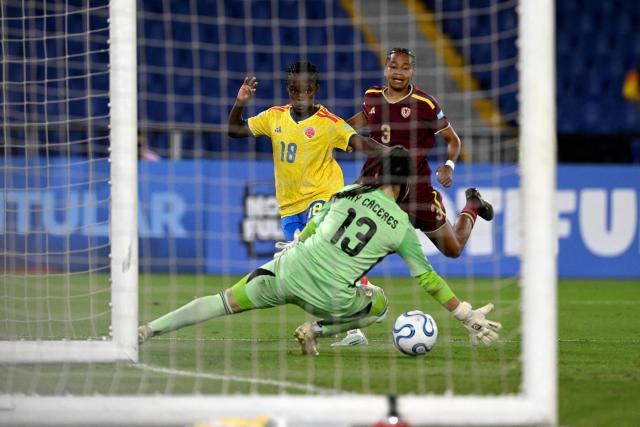 Colombia's forward #18 Linda Caicedo kicks the ball past Venezuela's goalkeeper #13 Nayluisa Caceres and defender #03 Barbara Martinez during the CONMEBOL Nations League Women football match between Colombia and Venezuela at the Olímpico Pascual Guerrero stadium in Cali, Valle del Cauca, Colombia, on April 10, 2026. (Photo by JOAQUIN SARMIENTO / AFP)