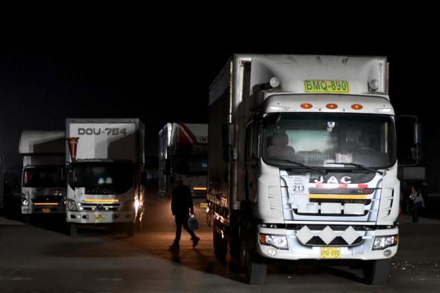Trucks loaded with voting materials are parked at Peru's National Office of Electoral Processes (ONPE) facilities in Lima on April 10, 2026. (Photo by Luis ROBAYO / AFP)