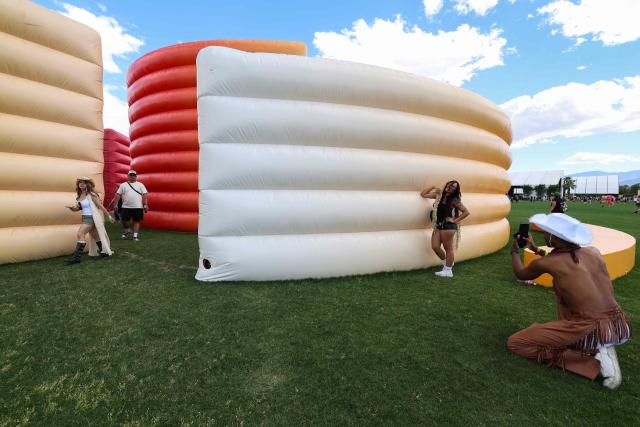 A festival-goer poses in front of the maze structure during the 2026 Coachella Valley Music and Arts Festival at the Empire Polo Club in Indio, California on April 10, 2026. (Photo by VALERIE MACON / AFP)