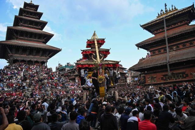 Devotees pull a wooden chariot carrying an idol of the Hindu deity Bhairav during the 'Bisket Jatra' festival marking the Nepali New Year in Bhaktapur on the outskirts of Kathmandu on April 10, 2026. (Photo by Prakash MATHEMA / AFP)