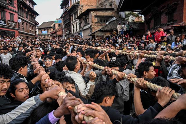 Devotees pull a wooden chariot carrying an idol of the Hindu deity Bhairav during the 'Bisket Jatra' festival marking the Nepali New Year in Bhaktapur on the outskirts of Kathmandu on April 10, 2026. (Photo by Prakash MATHEMA / AFP)
