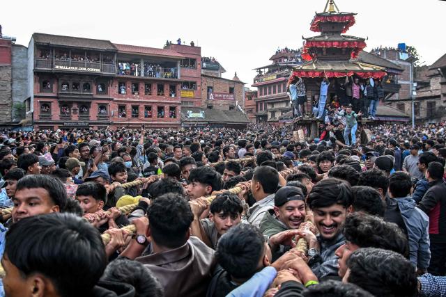 Devotees pull a wooden chariot carrying an idol of the Hindu deity Bhairav during the 'Bisket Jatra' festival marking the Nepali New Year in Bhaktapur on the outskirts of Kathmandu on April 10, 2026. (Photo by Prakash MATHEMA / AFP)