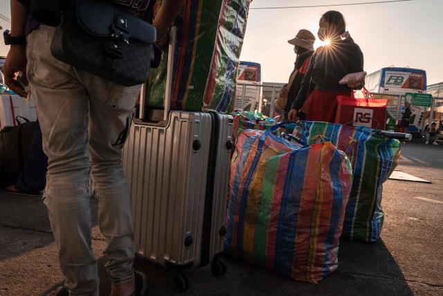 People wait with bags for their bus at the Mo Chit 2 terminal in Bangkok on April 10, 2026, ahead of Thai New Year or Songkran celebrations. (Photo by chanakarn LAOSARAKHAM / AFP)