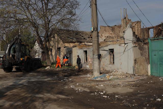 Communal workers clean debris next to a destroyed house following an air attack in Odesa on April 11, 2026, amid the Russian invasion in Ukraine. Russian strikes killed two people in Ukraine's southern Odesa, a military official said on April 11, 2026, shortly before a temporary ceasefire for Orthodox Easter was set to begin. (Photo by Oleksandr GIMANOV / AFP)