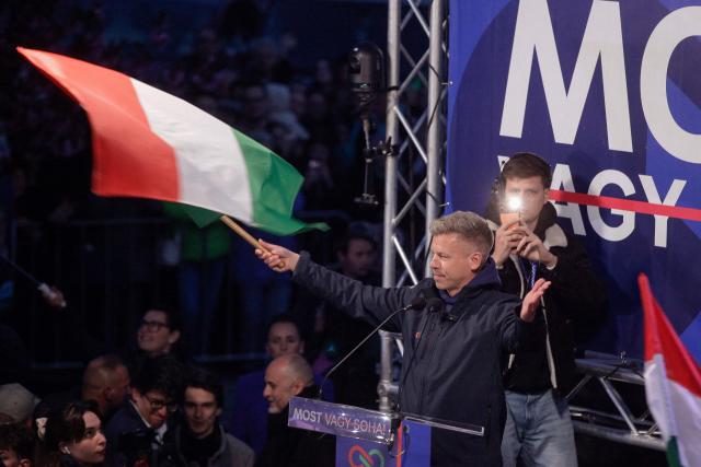 TOPSHOT - Peter Magyar, head of the Tisza party, waves the Hungarian flag as he addresses supporters during a campaign rally in Miskolc, Hungary, on April 10, 2026, during his nationwide tour, two days before the elections. (Photo by PETER KOHALMI / AFP)