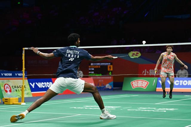 India's Ayush Shetty (L) hits a return to Thailand's Kunlavut Vitidsarn during their men's singles semifinal match at the Badminton Asia Championship in Ningbo, eastern China's Zhejiang province on April 11, 2026. (Photo by CN-STR / AFP) / China OUT
