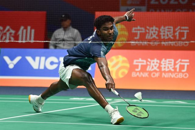 India's Ayush Shetty hits a return to Thailand's Kunlavut Vitidsarn during their men's singles semifinal match at the Badminton Asia Championship in Ningbo, eastern China's Zhejiang province on April 11, 2026. (Photo by CN-STR / AFP) / China OUT
