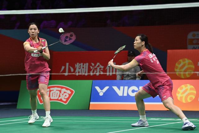 Li Yijing (L) and Luo Xumin of China hit a return to Yuki Fukushima and Mayu Matsumoto of Japan during their women's doubles semifinal match at the Badminton Asia Championship in Ningbo, eastern China's Zhejiang province on April 11, 2026. (Photo by CN-STR / AFP) / China OUT