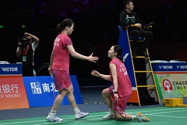 Li Yijing (R) and Luo Xumin of China celebrate after winning their women's doubles semifinal match agaisnt Yuki Fukushima and Mayu Matsumoto of Japan at the Badminton Asia Championship in Ningbo, eastern China's Zhejiang province on April 11, 2026. (Photo by CN-STR / AFP) / China OUT