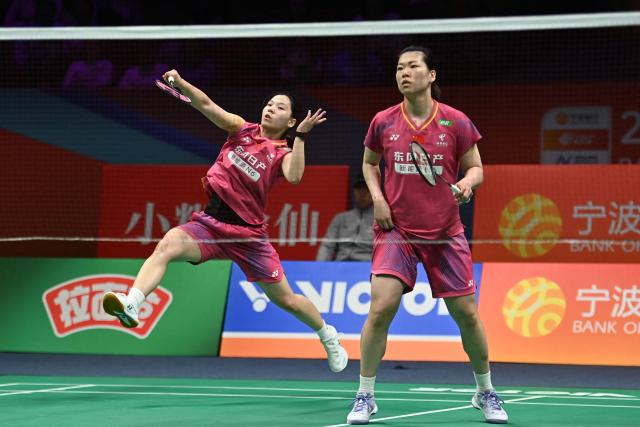 Li Yijing (L) and Luo Xumin of China hit a return to Yuki Fukushima and Mayu Matsumoto of Japan during their women's doubles semifinal match at the Badminton Asia Championship in Ningbo, eastern China's Zhejiang province on April 11, 2026. (Photo by CN-STR / AFP) / China OUT