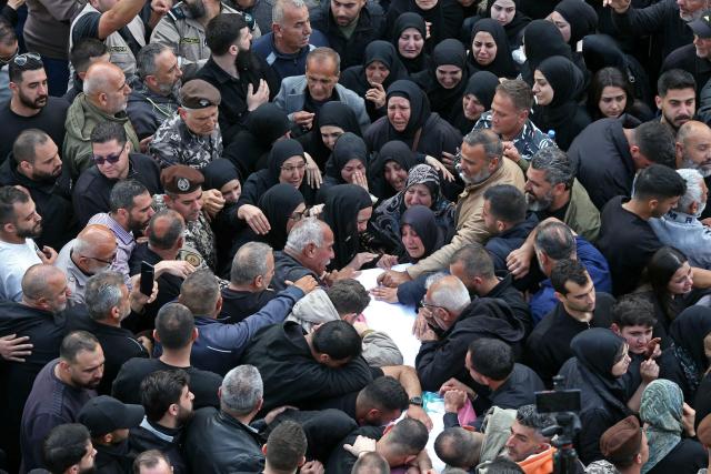 Mourners gather around the coffin of a member of Lebanon's State Security agency, who was killed by an Israeli strike, during their funeral in Sidon on April 11, 2026. The agency said that one Israeli strike in the southern city of Nabatiyeh had killed 13 of its personnel. Lebanon's presidency said on April 10 that a meeting would be held with Israel in Washington next week to discuss a ceasefire in the Israel-Hezbollah war and the start of negotiations between the neighbours. (Photo by MAHMOUD ZAYYAT / AFP)