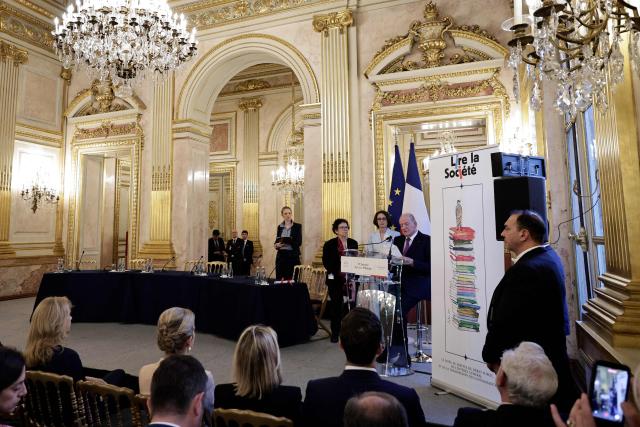 Spain's former King Juan Carlos I (R) delivers a speech flanked by French historian Annette Wieviorka (3rd R) and French writer Laurence Debray (2nd R) during the 35th "Journee du Livre Politique", an annual event dedicated to political books, at the National Assembly of France in Paris on April 11, 2026. (Photo by STEPHANE DE SAKUTIN / AFP)