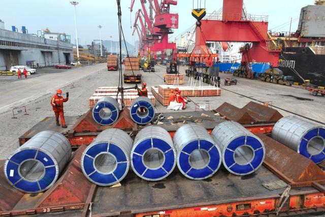 Workers handle steel coils for shipment at the Dongfang Port Company terminal of Lianyungang Port, in China's eastern Jiangsu province, on April 11, 2026. (Photo by CN-STR / AFP) / China OUT