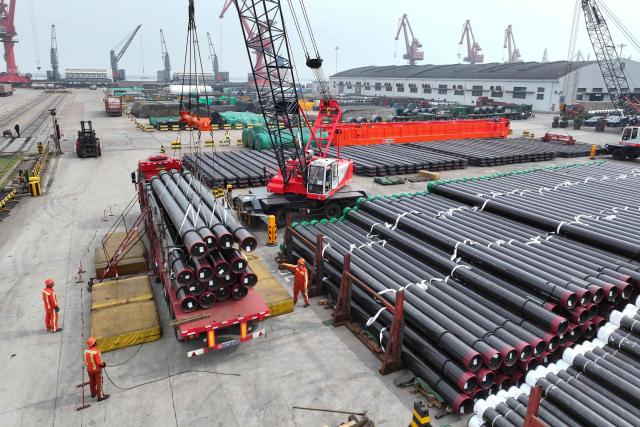 Workers handle steel pipes for shipment at the Dongfang Port Company terminal of Lianyungang Port, in China's eastern Jiangsu province, on April 11, 2026. (Photo by CN-STR / AFP) / China OUT