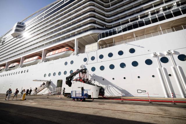 This photograph shows the MSC World Europa cruise boat moored at the Marseille cruise terminal while being charged using a "Cable Management System" at the Grand Port Maritime de Marseille, in Marseille, south-eastern France on April 11, 2026. Those systems allow boats to turn their engine off during their stay in Marseille harbour and to be charged by electricity. This new facilities are able to connect simultaneously three large cruise ships via electrical connection aiming to reduce smoke, vibrations and noise pollution in the city center. (Photo by CLEMENT MAHOUDEAU / AFP)