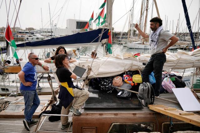 Pro-Palestinian activists coordinate on board a boat filled with supplies and personal belongings on the eve of the departure of a new humanitarian flotilla bound for the Gaza Strip, in Barcelona, on April 11, 2026. A new flotilla of more than 80 boats and 1,000 international pro-Palestinian activists, who attempted to reach Gaza last year, is preparing for a new mission to the devastated territory from Barcelona tomorrow. Israel's response to the Global Sumud Flotilla's first journey —intercepting the boats and arresting the activists— sparked international condemnation. (Photo by Manaure Quintero / AFP)