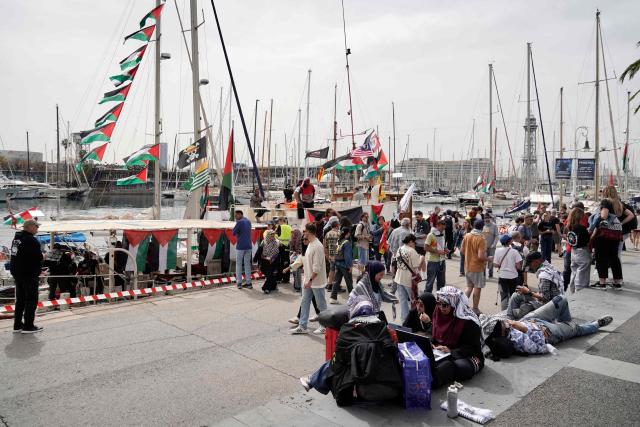 Pro-Palestinian activists gather on the quayside next to boats decorated with Palestinian flags at the port of Barcelona, on April 11, 2026, on the eve of the departure of a new humanitarian flotilla bound for the Gaza Strip. A new flotilla of more than 80 boats and 1,000 international pro-Palestinian activists, who attempted to reach Gaza last year, is preparing for a new mission to the devastated territory from Barcelona tomorrow. Israel's response to the Global Sumud Flotilla's first journey —intercepting the boats and arresting the activists— sparked international condemnation. (Photo by Manaure Quintero / AFP)