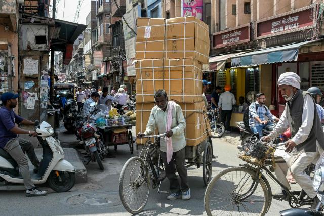 A man pulls a three-wheeled cart as he transports goods across a market area in Amritsar on April 11, 2026. (Photo by Narinder NANU / AFP)
