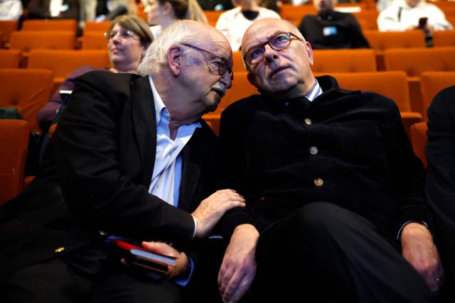 French writer and member of the French Academy Erik Orsenna (L) speaks with former French Prime Minister Bernard Cazeneuve during a debate session of the “Grand Dйbat des Gracques” on major national issues, at the Theatre de la Cite Internationale in Paris on April 11, 2026. (Photo by Ian LANGSDON / AFP)