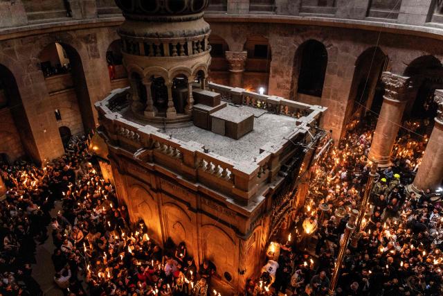 Orthodox Christian worshippers hold up candles during the annual Holy Fire ceremony at Jerusalem’s Church of the Holy Sepulchre  on April 11, 2026. (Photo by JOHN WESSELS / AFP)