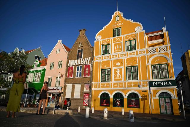 Tourists are seen at the historical center in Willemstad, in the Dutch Caribbean, on April 10, 2026. (Photo by Raul ARBOLEDA / AFP)