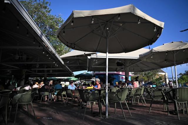 Tourists sit at an open-air cafeteria at the historical center in Willemstad, in the Dutch Caribbean, on April 10, 2026. (Photo by Raul ARBOLEDA / AFP)
