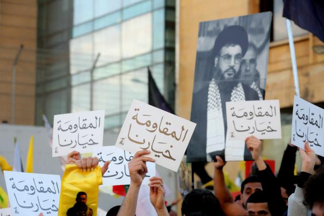Hezbollah supporters, one holding up an image Lebanon's slain Hezbollah leader Hasan Nasrallah, and placards that read, 'Resistance is our choice', demonstrate near the Governmental Palace to protest the Lebanese authorities decision to engage in direct negotiations with Israel to end the ongoing war, in downtown Beirut on April 11, 2026. Hezbollah lawmaker reiterated on April 11, his group's rejection of direct negotiations between Israel and Lebanon, where authorities reported 10 people killed in Israeli attacks in the south. The office of the Lebanese president said on April 10, that officials from his country, Israel and the United States would meet next week in Washington "to discuss declaring a ceasefire and the start date for negotiations between Lebanon and Israel under US auspices". (Photo by ibrahim AMRO / AFP)