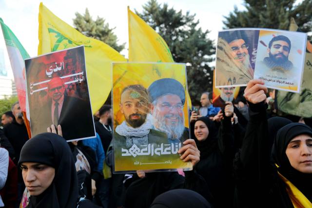 Hezbollah supporters, some waving the yellow party flag and holding up an image Lebanon's slain Hezbollah leader Hasan Nasrallah (2nd & 3rd R), demonstrate near the Governmental Palace to protest the Lebanese authorities decision to engage in direct negotiations with Israel to end the ongoing war, in downtown Beirut on April 11, 2026. Hezbollah lawmaker reiterated on April 11, his group's rejection of direct negotiations between Israel and Lebanon, where authorities reported 10 people killed in Israeli attacks in the south. The office of the Lebanese president said on April 10, that officials from his country, Israel and the United States would meet next week in Washington "to discuss declaring a ceasefire and the start date for negotiations between Lebanon and Israel under US auspices". (Photo by Ibrahim AMRO / AFP)