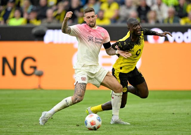 Dortmund's Guinean forward #09 Serhou Guirassy (R) and Bayer Leverkusen's German midfielder #08 Robert Andrich vie for the ball during the German first division Bundesliga football match between Borussia Dortmund and Bayer Leverkusen in Dortmund, western Germany, on April 11, 2026. (Photo by INA FASSBENDER / AFP) / DFL REGULATIONS PROHIBIT ANY USE OF PHOTOGRAPHS AS IMAGE SEQUENCES AND/OR QUASI-VIDEO